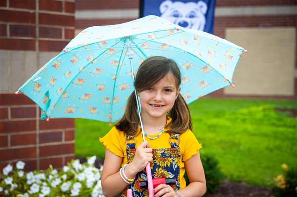 girl smiling with blue umbrella
